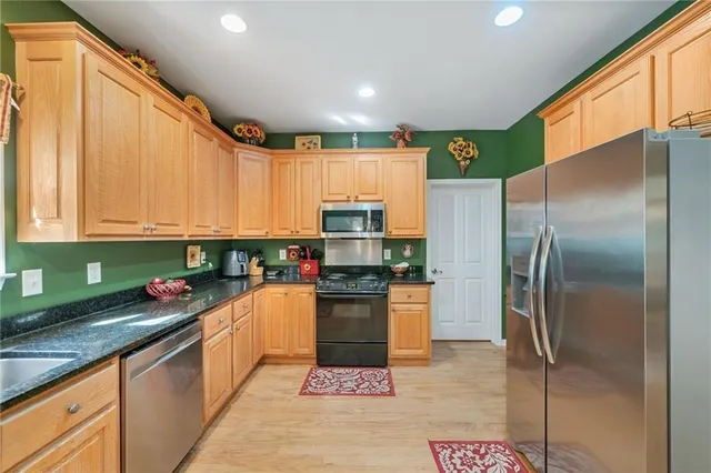 a kitchen with stainless steel appliances granite countertop a refrigerator and a stove top oven
