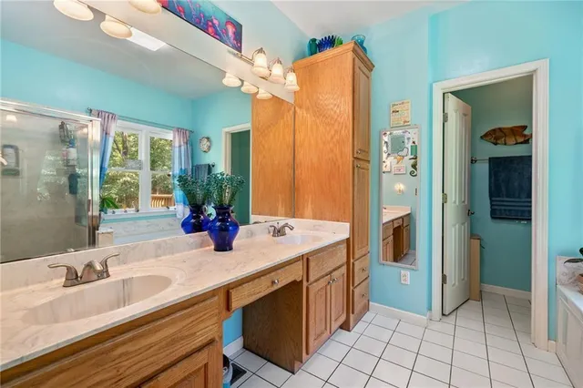 a bathroom with a double vanity sink a mirror and a bathtub