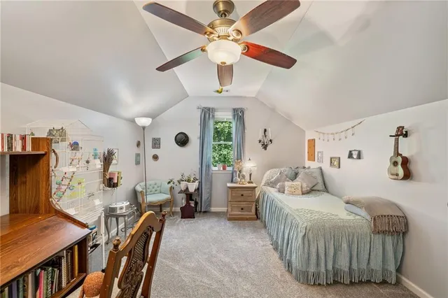 a bedroom with a bed couch and a chandelier