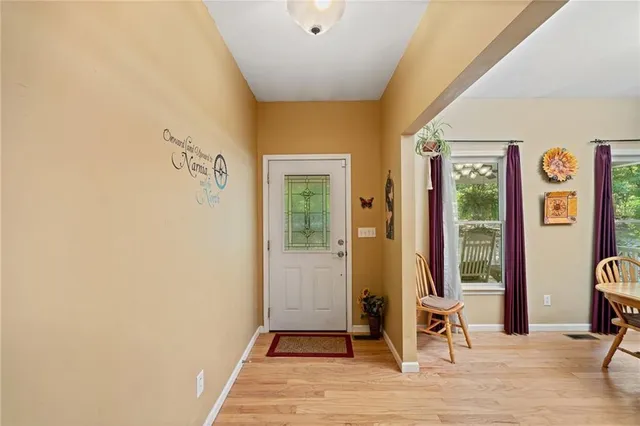 a view of a livingroom with wooden floor and furniture