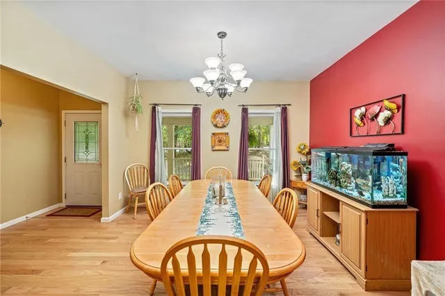 a view of a dining room with furniture a chandelier and wooden floor