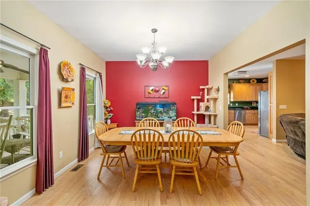 a view of a dining room with furniture a chandelier and wooden floor
