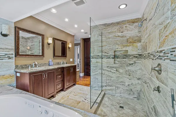a bathroom with a granite countertop sink mirror bathtub shower and double