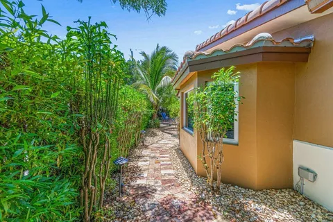a view of a pathway of a house with potted plants
