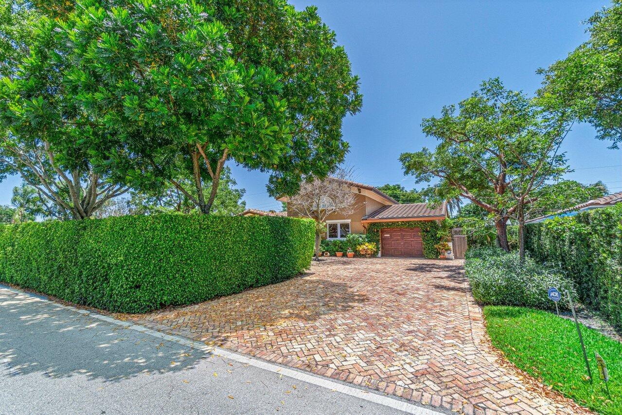 870 Northwest 7th Street Boca Raton, FL 33486 - Photo 5 of 37 a front view of a house with a yard and a garage