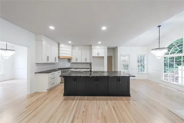 a large kitchen with wooden floors and stainless steel appliances
