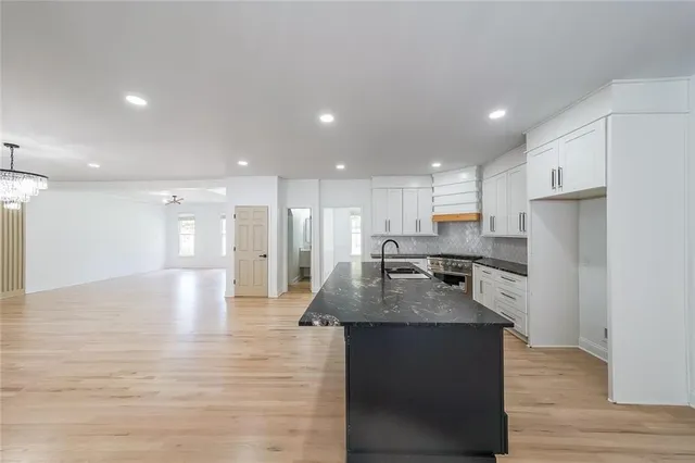 a kitchen with stainless steel appliances granite countertop a sink a refrigerator and a stove