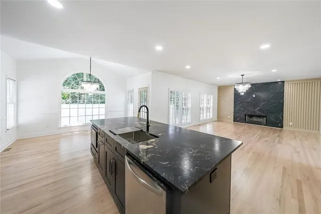 a kitchen with stainless steel appliances granite countertop a sink window and wooden floor
