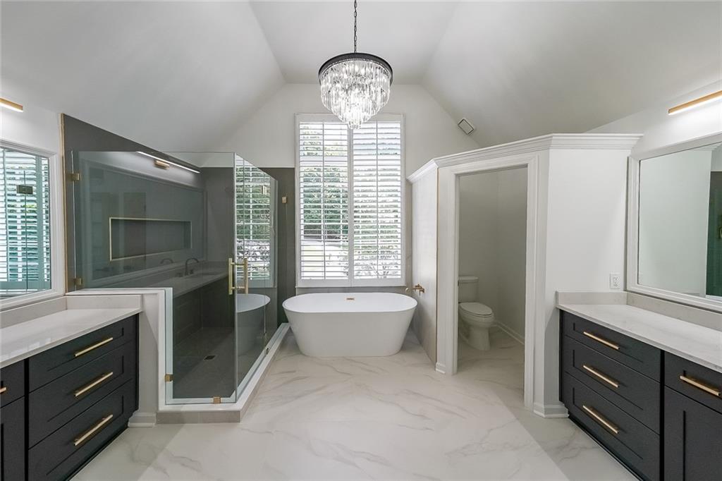 2130 Federal Road Roswell, GA 30075 - Photo 19 of 34 a spacious bathroom with a toilet a sink a mirror and a window