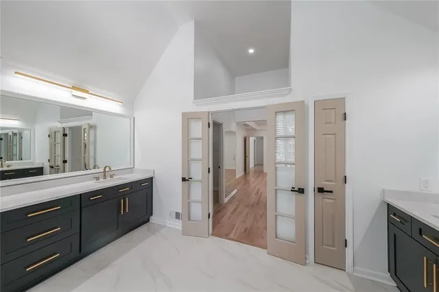 a spacious bathroom with a double vanity sink a mirror and a shower