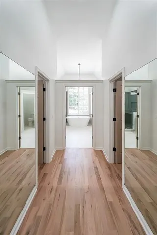 wooden floor in an empty room with wooden floor and a bathroom