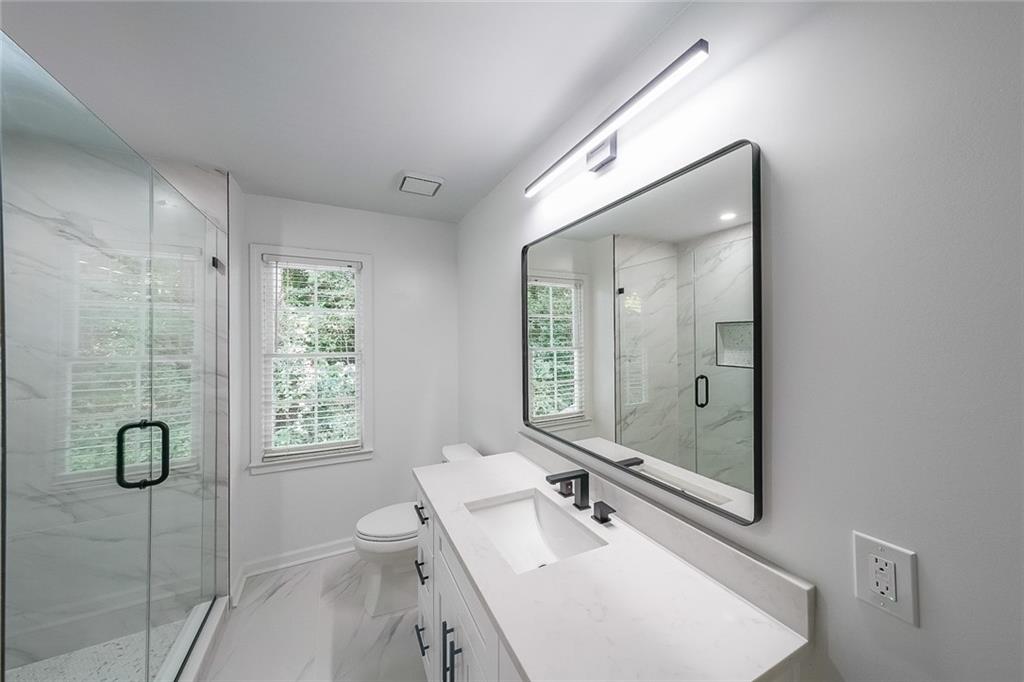 2130 Federal Road Roswell, GA 30075 - Photo 29 of 34 a bathroom with a granite countertop sink a toilet and shower