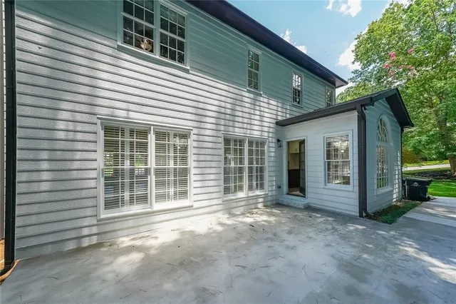 a view of a house with a backyard and large windows