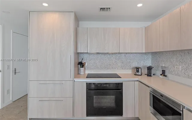 a kitchen with cabinets appliances a sink and a counter top
