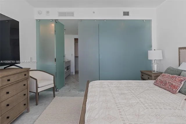 a bedroom with furniture and a flat screen tv