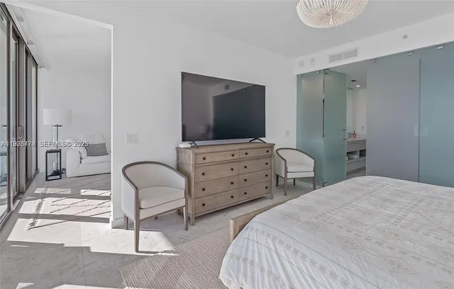 a bedroom with a bed and a lamp next to a large window