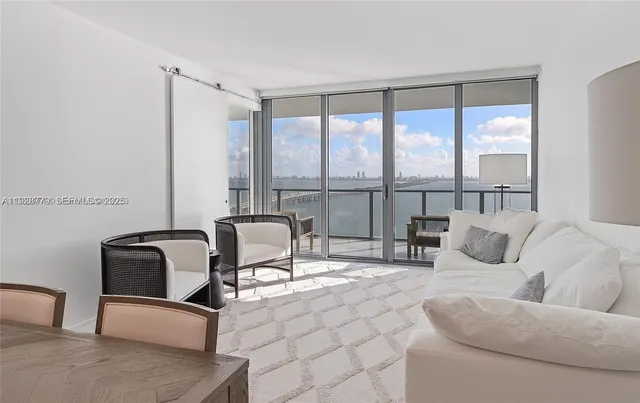 a living room with furniture and a floor to ceiling window