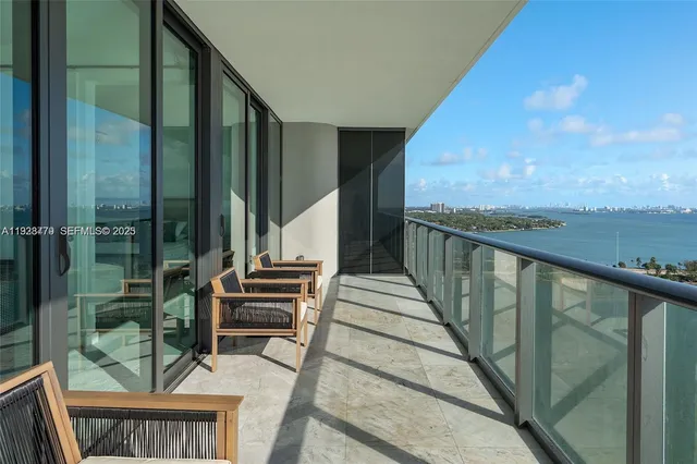 a view of a balcony with chairs and wooden floor
