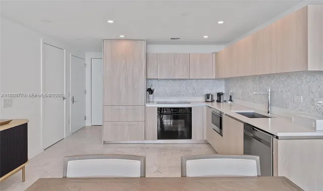 a dining room with furniture a chandelier and a large window