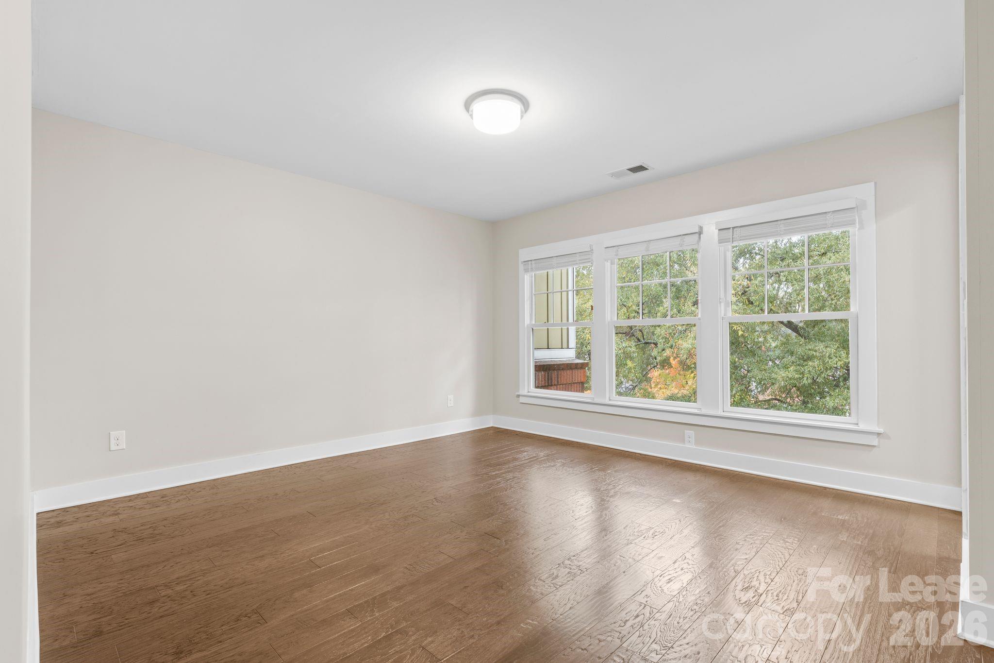 129 Grandin Road Charlotte, NC 28208 - Photo 16 of 26 an empty room with wooden floor and windows