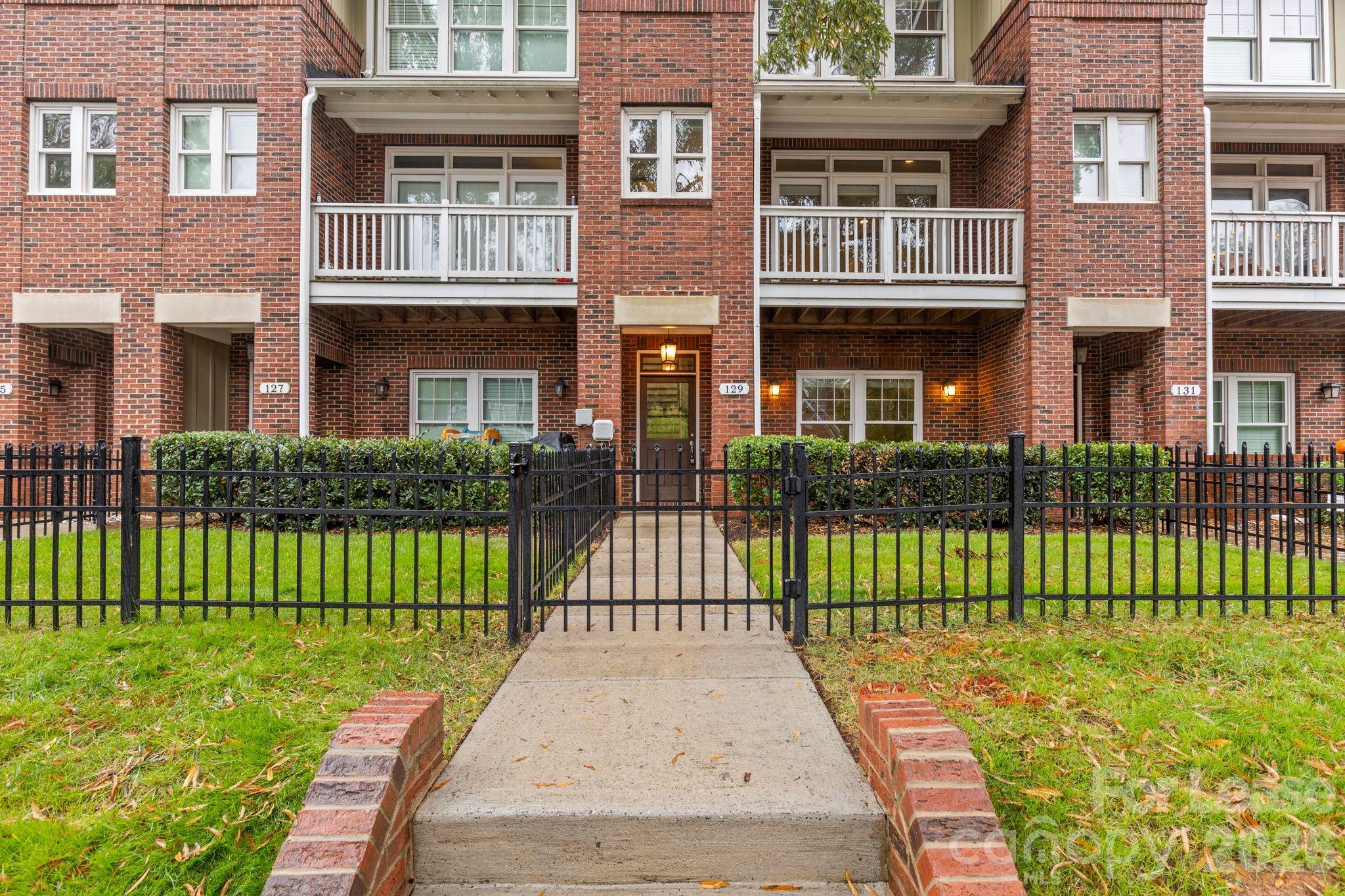 129 Grandin Road Charlotte, NC 28208 - Photo 2 of 26 a view of a brick house with a yard and plants