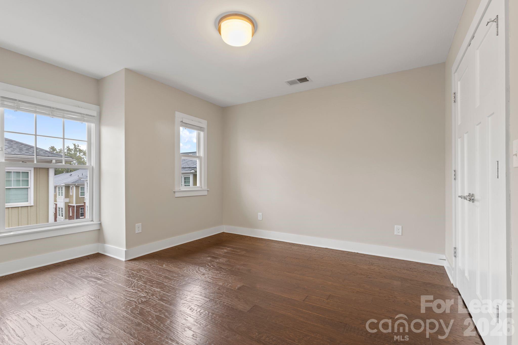 129 Grandin Road Charlotte, NC 28208 - Photo 21 of 26 an empty room with wooden floor and windows
