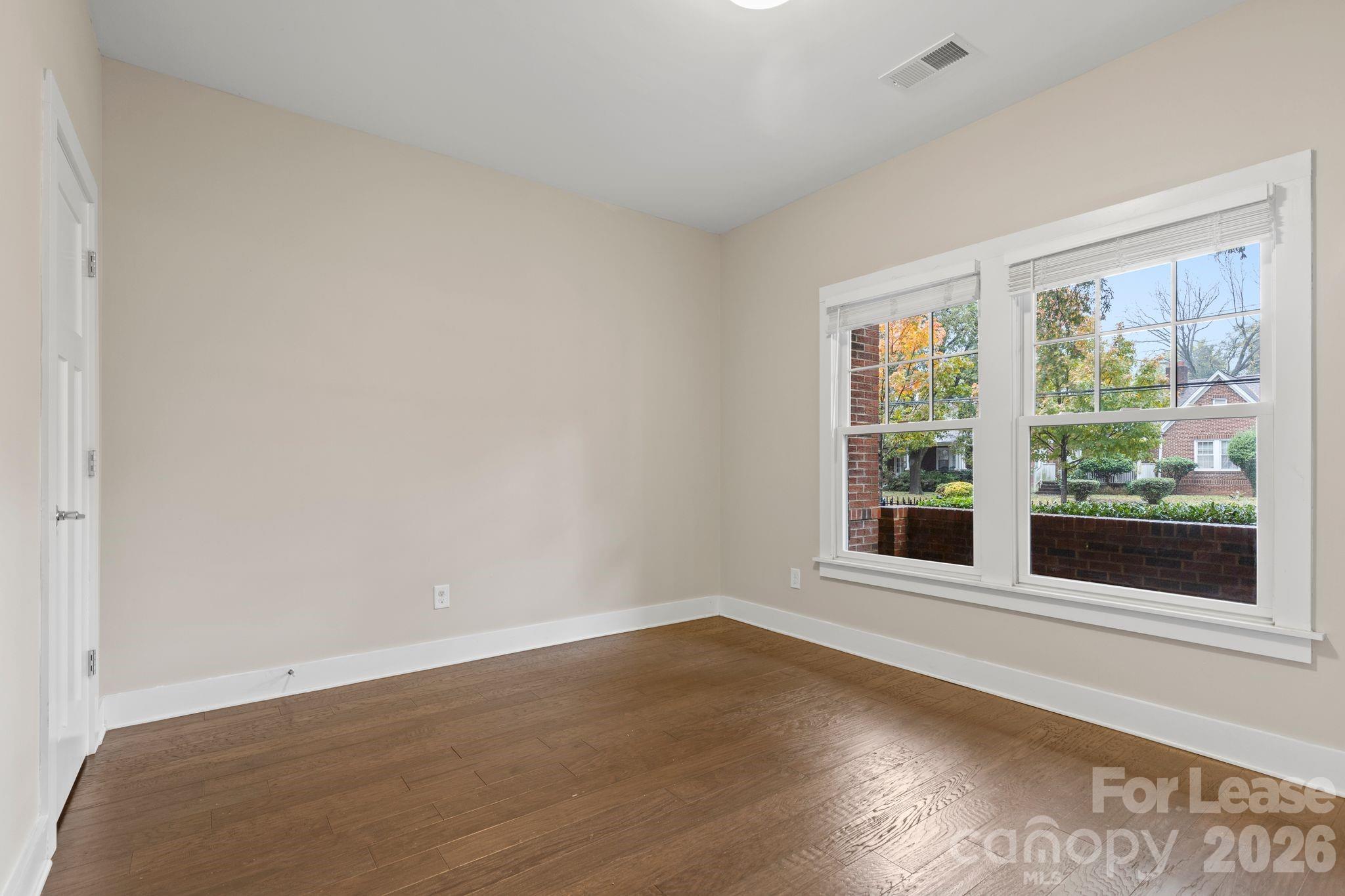 129 Grandin Road Charlotte, NC 28208 - Photo 3 of 26 an empty room with wooden floor and windows
