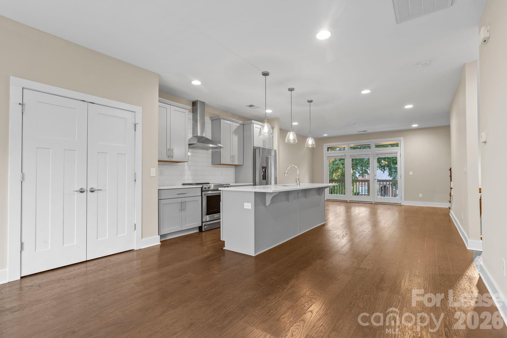 129 Grandin Road Charlotte, NC 28208 - Photo 8 of 26 a large white kitchen with kitchen island a sink stainless steel appliances and cabinets