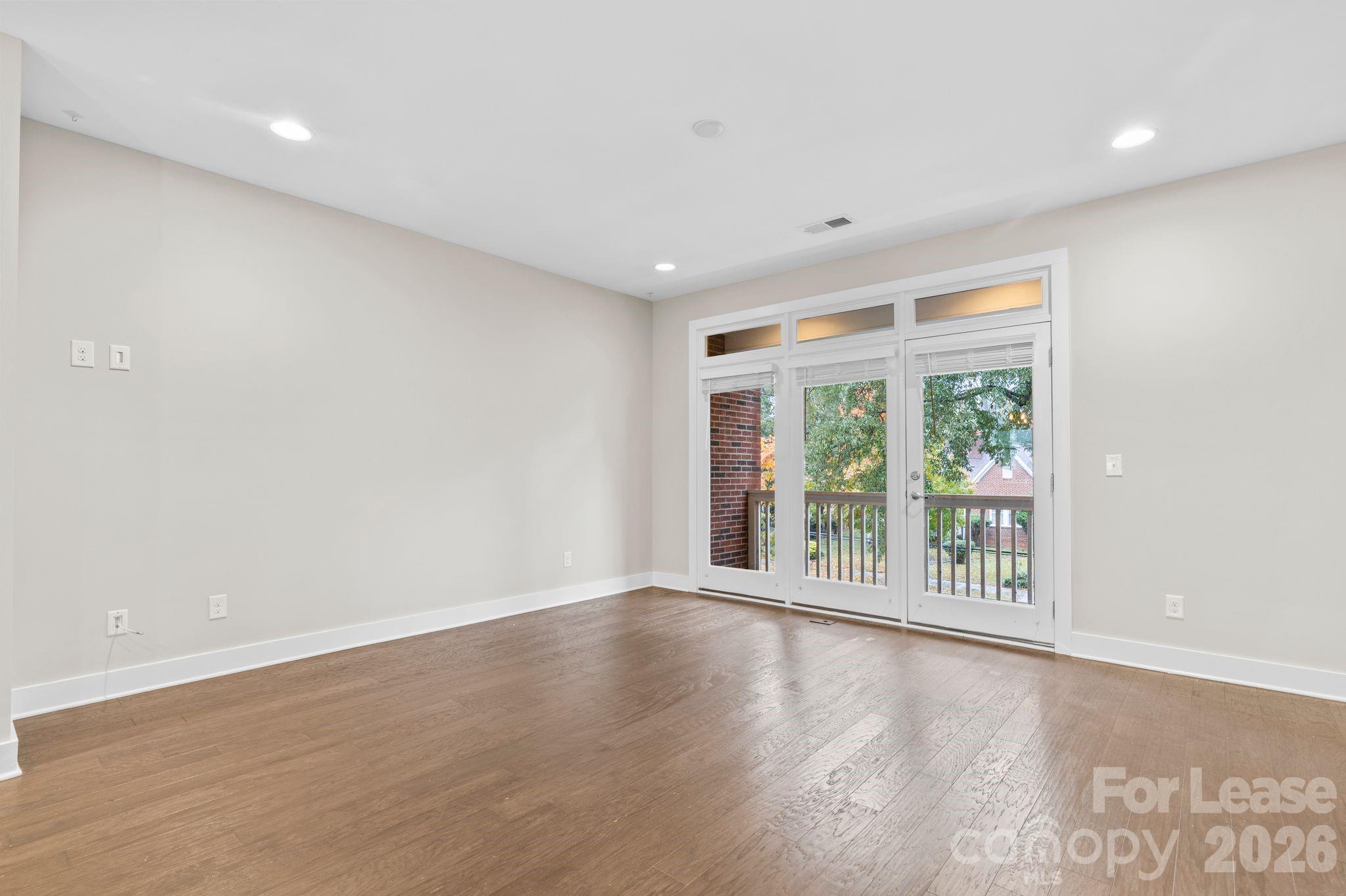 129 Grandin Road Charlotte, NC 28208 - Photo 10 of 26 a view of an empty room with wooden floor and a window