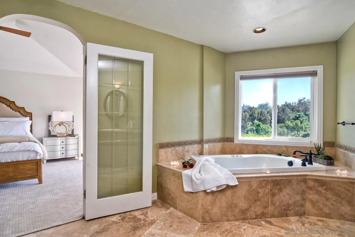 5460 La Crescenta Road Rancho Santa Fe, CA 92067 - Photo 18 of 27 a bed sitting in a spacious bedroom next to a window