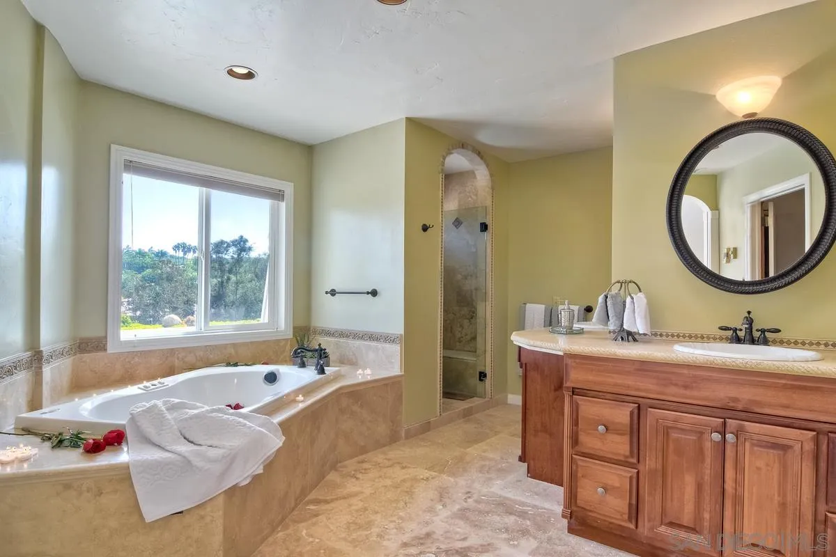 5460 La Crescenta Road Rancho Santa Fe, CA 92067 - Photo 19 of 27 a spacious bathroom with a tub sink and mirror