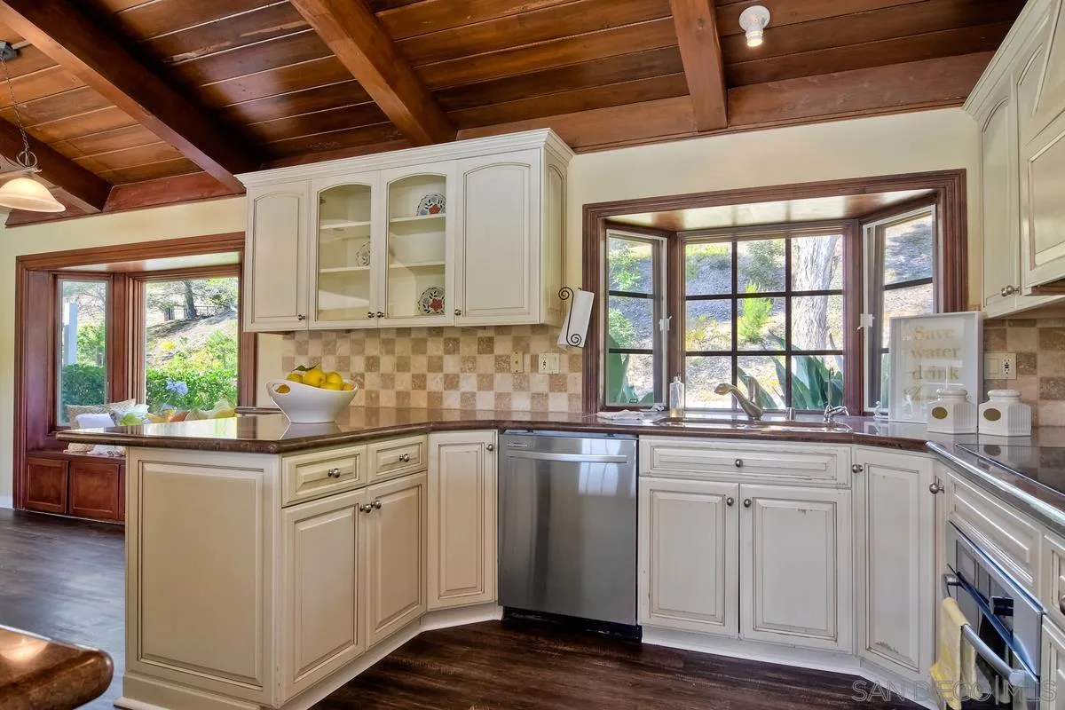 5460 La Crescenta Road Rancho Santa Fe, CA 92067 - Photo 6 of 27 a kitchen with granite countertop white cabinets and white appliances