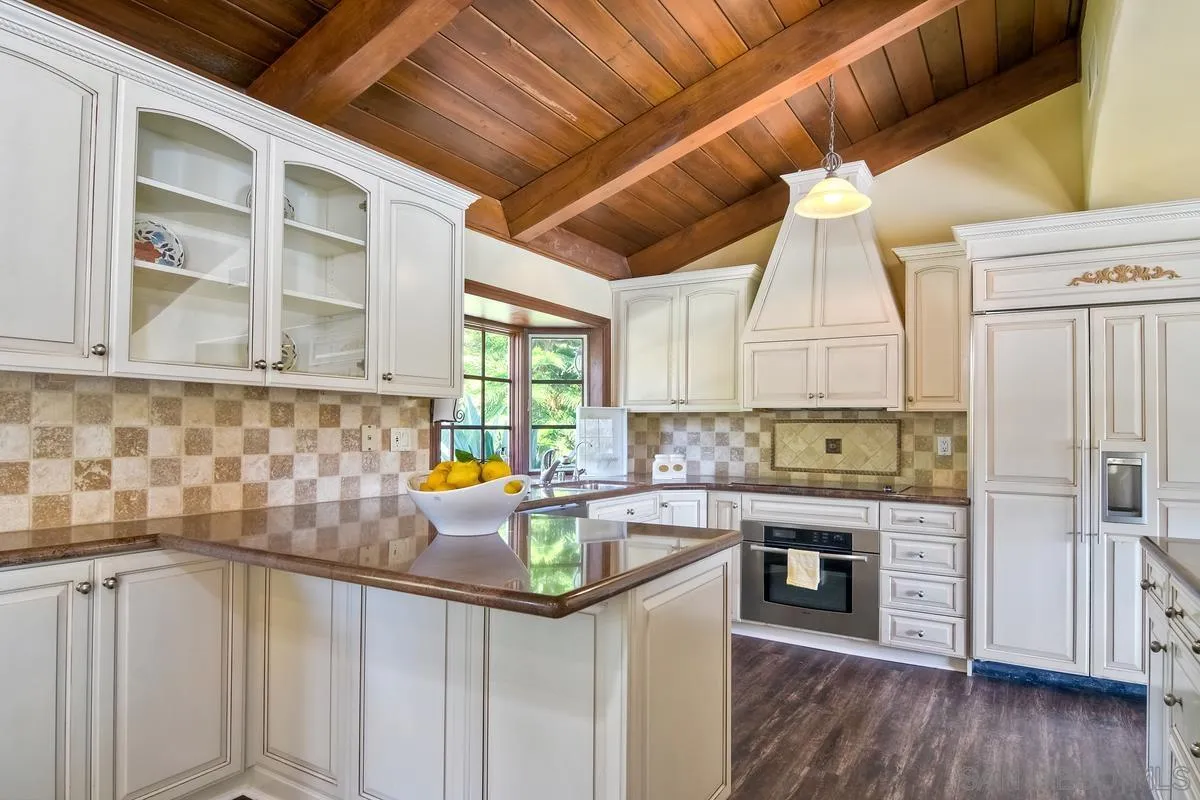 5460 La Crescenta Road Rancho Santa Fe, CA 92067 - Photo 7 of 27 a kitchen with stainless steel appliances granite countertop a sink a stove cabinets counter space and a window