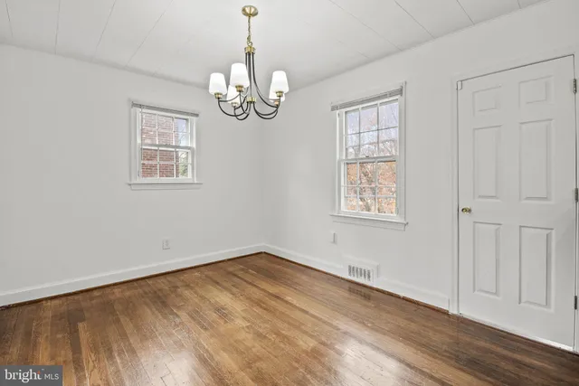 a view of empty room with wooden floor and window