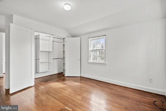 a view of empty room with wooden floor