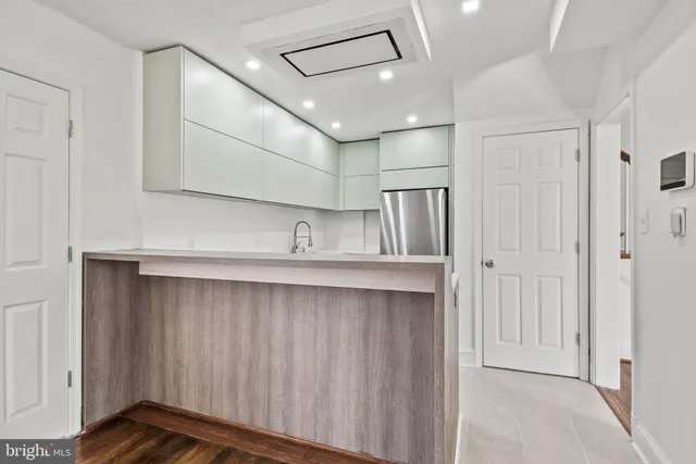 a view of a kitchen with a sink and wooden cabinets
