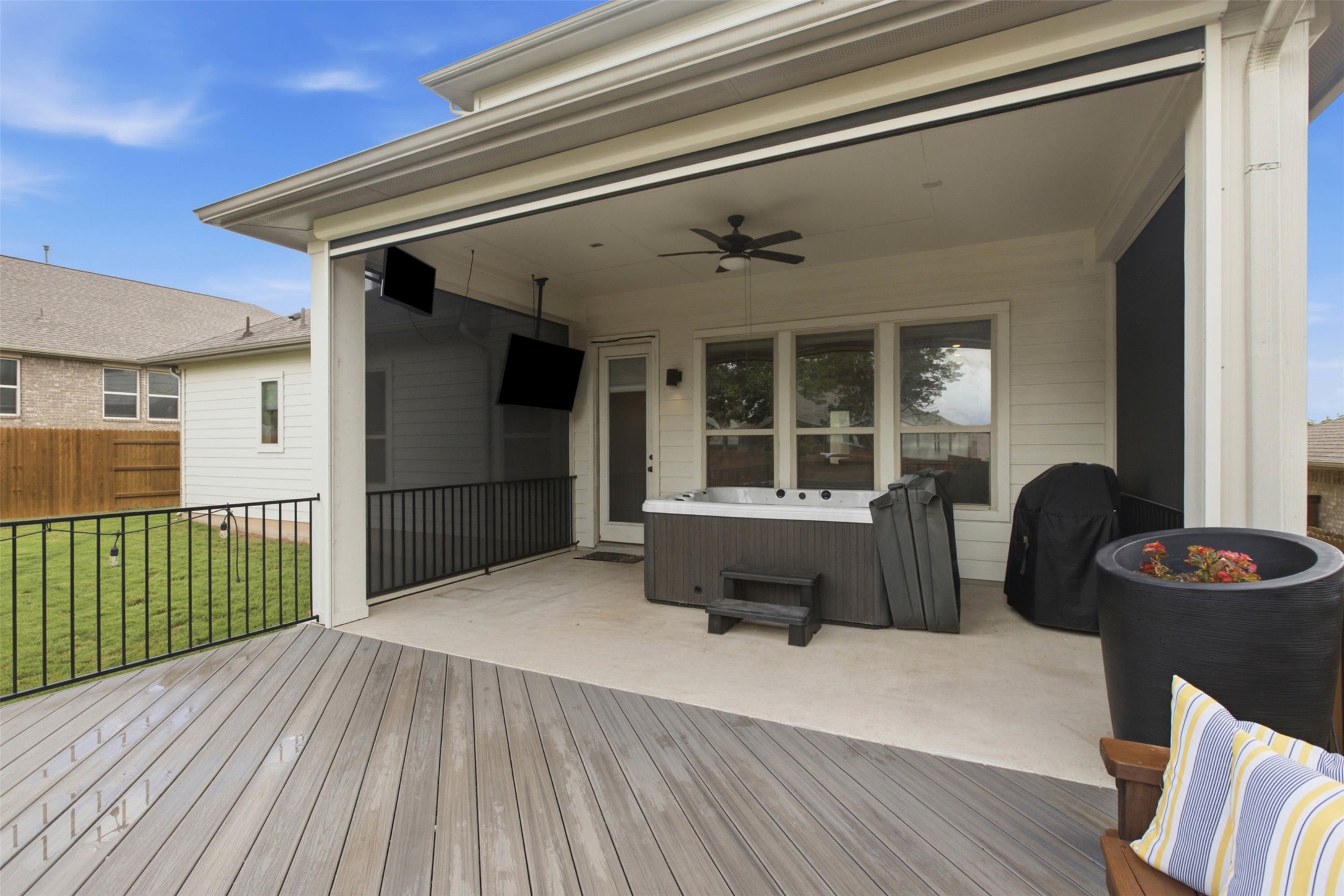 1113 Modoc Way Kyle, TX 78640 - Photo 29 of 34 A spacious covered patio features a hot tub, ceiling fan, and ample room for entertaining.
