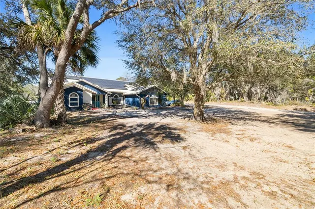 a backyard of a house with table and chairs