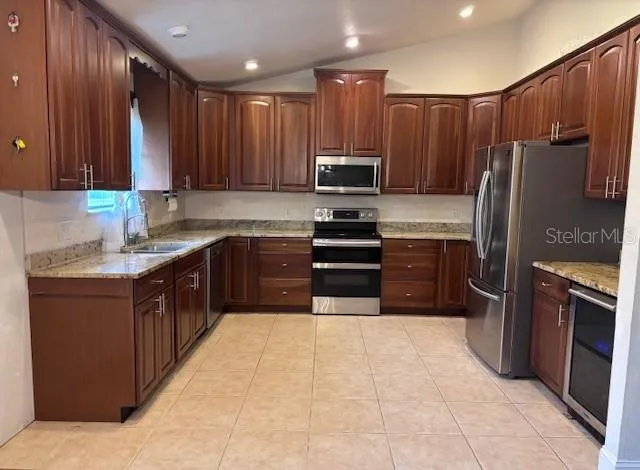 a kitchen with kitchen island granite countertop a sink counter top space stainless steel appliances and cabinets