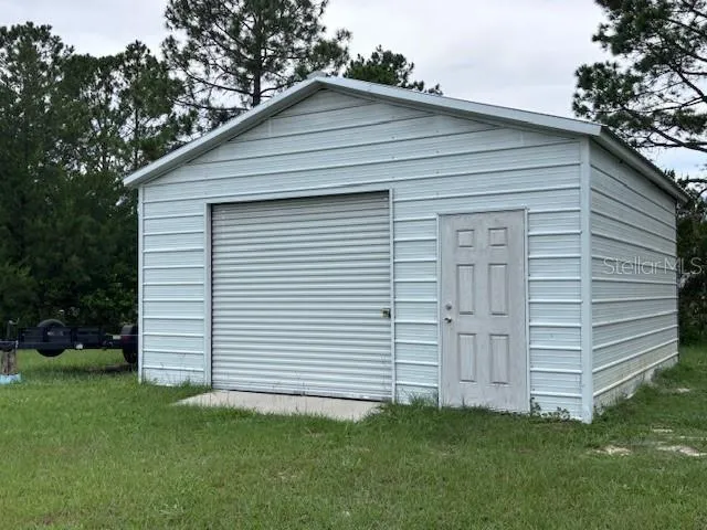 a view of a white house in the back yard