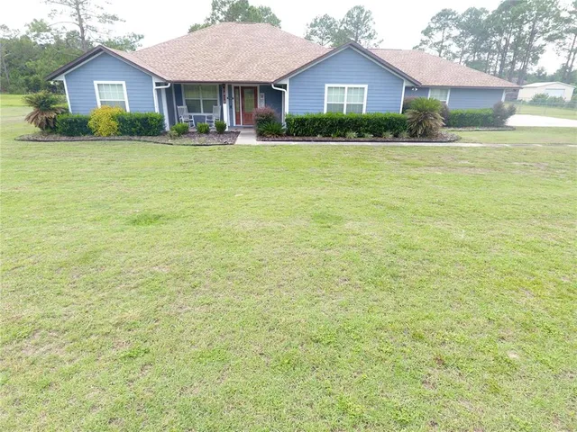 a front view of a house with a garden