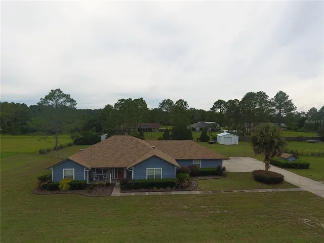a aerial view of a house with yard and lake view