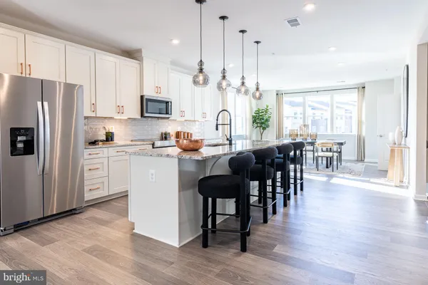 a kitchen with a table chairs refrigerator and cabinets