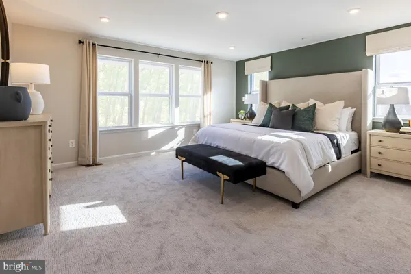 a spacious bedroom with a bed and a lamp