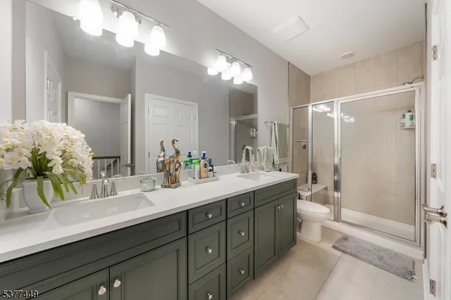 a bathroom with a double vanity sink mirror and shower