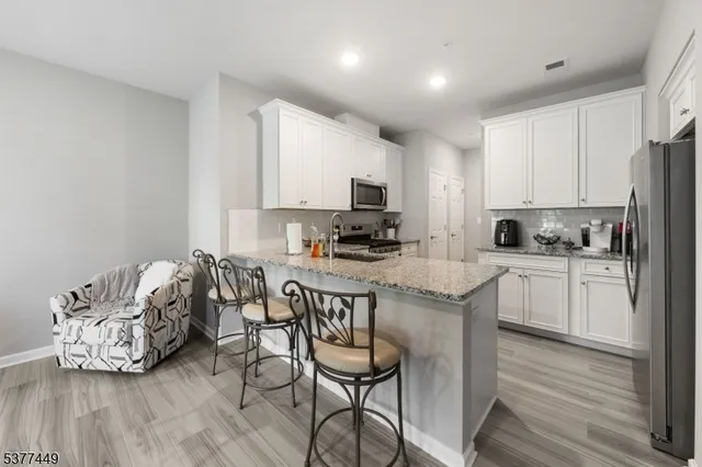 a kitchen with granite countertop a stove a sink a microwave and a refrigerator