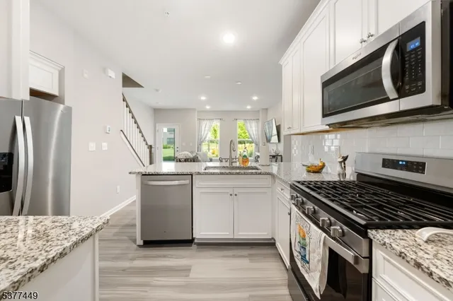 a kitchen with stainless steel appliances granite countertop a stove and a microwave