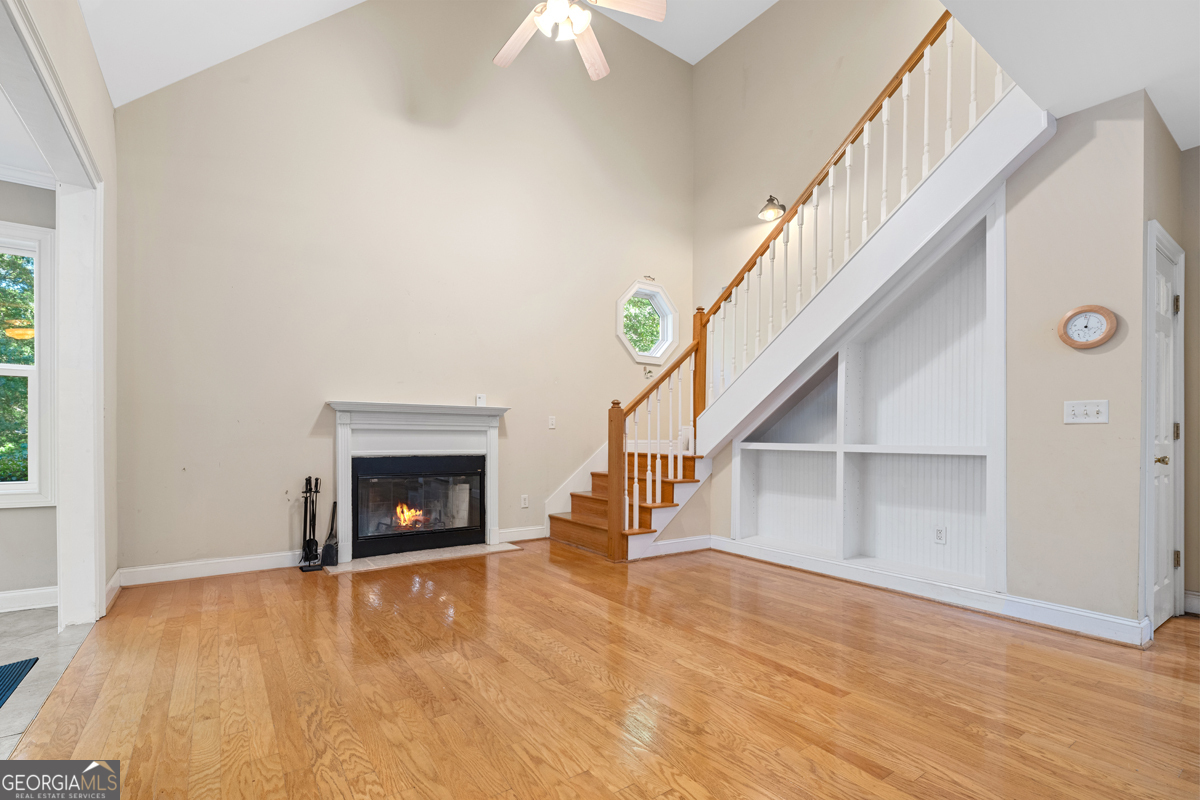 122 Hodges Lane Hartwell, GA 30643 - Photo 32 of 37 a view of an empty room with wooden floor fireplace and a window