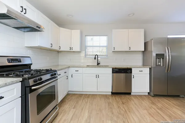 a kitchen with a stove top oven sink and cabinets