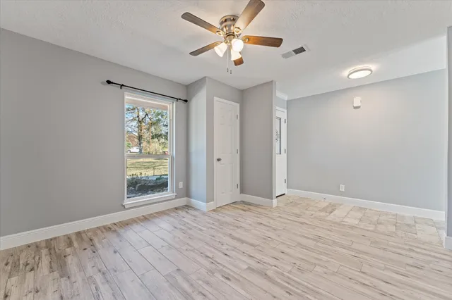 a view of an empty room with a chandelier fan
